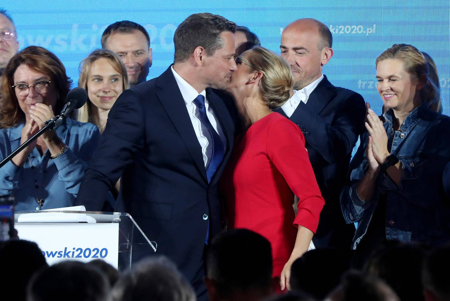 A top candidate in Poland's presidential election, Warsaw Mayor Rafal Trzaskowski,front, kisses his wife Malgorzata to exit poll after voting closed, in Warsaw, Poland, on Sunday, June 28, 2020. The poll suggests that Trzaskowski and incumbent president, Andrzej Duda, who won the most votes, will face each other in a runoff July 12. (AP Photo/Czarek Sokolowski)