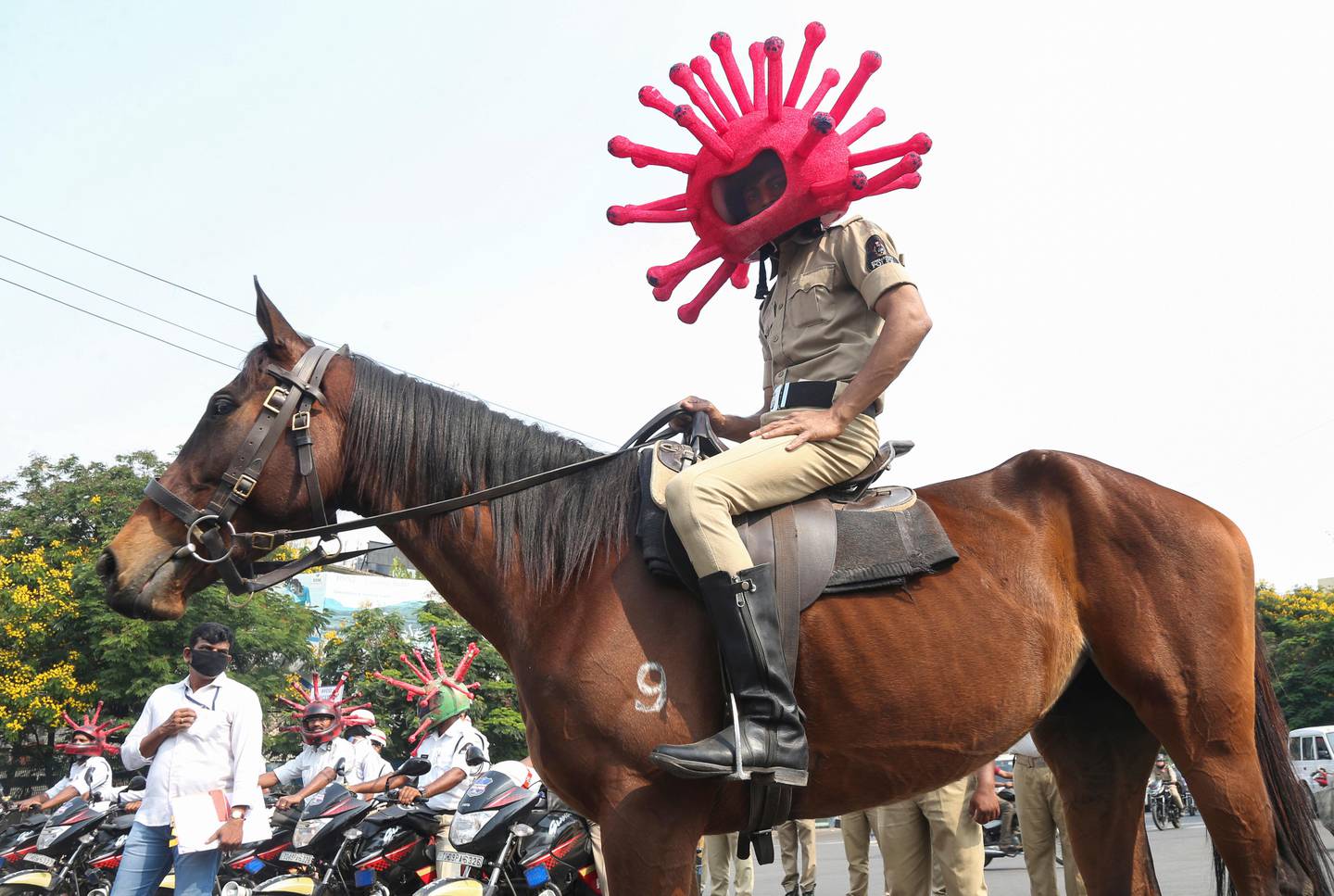 An Indian policeman wearing a virus themed helmet rides on a horse during an awareness rally aimed at preventing the spread of new coronavirus in Hyderabad, India, Thursday, April 2, 2020. The new coronavirus causes mild or moderate symptoms for most people, but for some, especially older adults and people with existing health problems, it can cause more severe illness or death. (AP Photo/Mahesh Kumar A.)