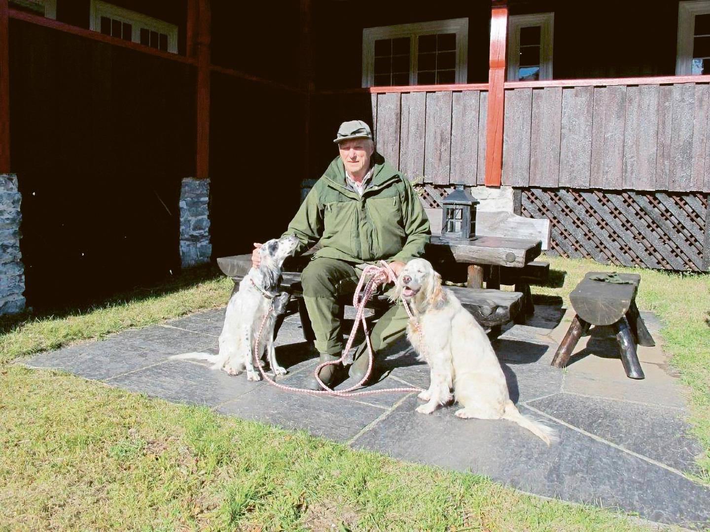 Kong Harald med hund på hyttetunet.