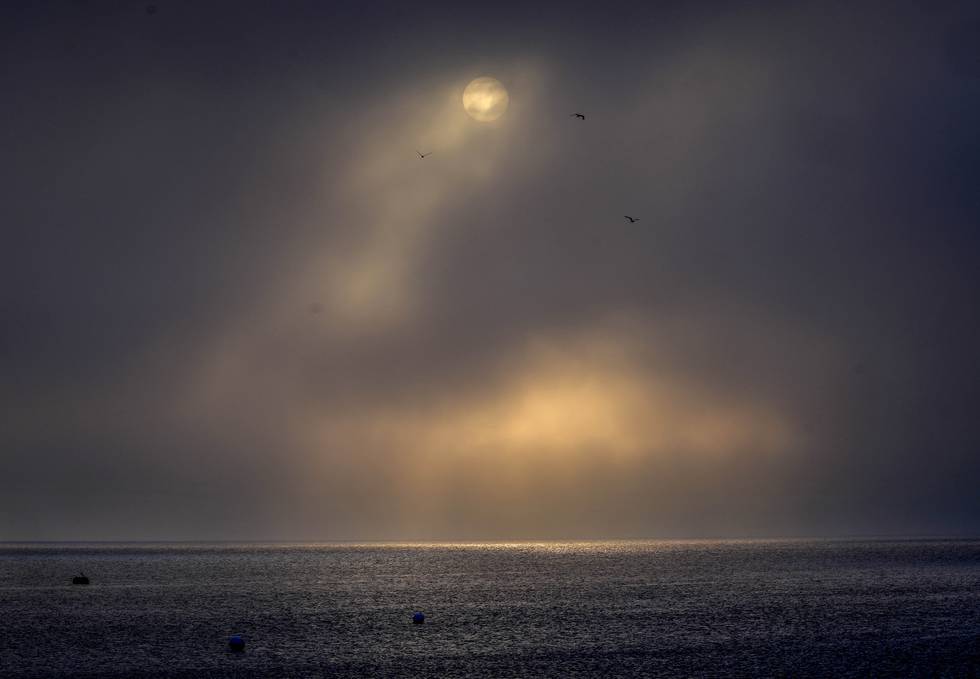 The rising sun is seen between clouds and fog over the Baltic Sea in Scharbeutz, Germany, Wednesday, Sept. 1, 2021. (AP Photo/Michael Probst)