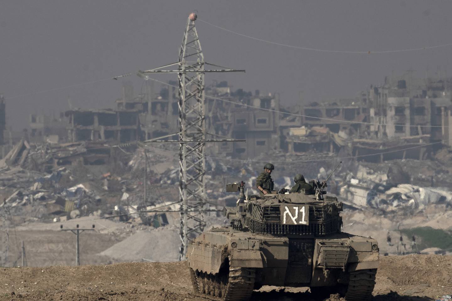 Israel hevder at deres hær driver en lovlig krig for å avverge flere angrep fra Hamas. Her en israelsk stridsvogn på en høyde med skue inn i Gaza fra Sør-Israel fredag. Foto: Maya Alleruzzo / AP / NTB