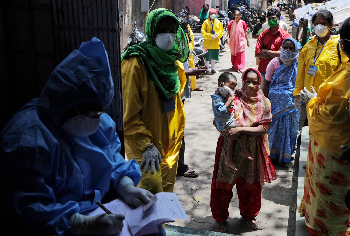 People wait to give their samples to medical staff at a slum area during lockdown to control the spread of the new coronavirus in Mumbai, India, Tuesday, April 7, 2020. The new coronavirus causes mild or moderate symptoms for most people, but for some, especially older adults and people with existing health problems, it can cause more severe illness or death. (AP Photo/Rajanish Kakade)