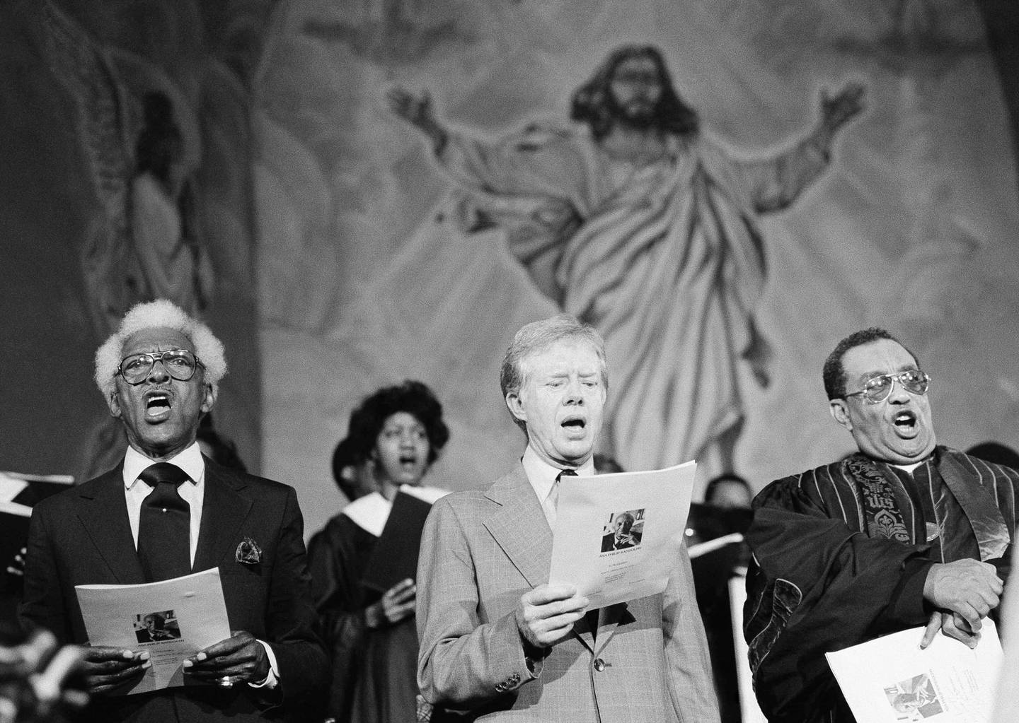President Jimmy Carter, along with Bayard Rustin, left, and Bishop Henry Murph sing at a memorial service for the late civil rights leader A. Philip Randolph, June 4, 1979 at the Washington Metropolitan African Methodist and Episcopal Church. (AP Photo)