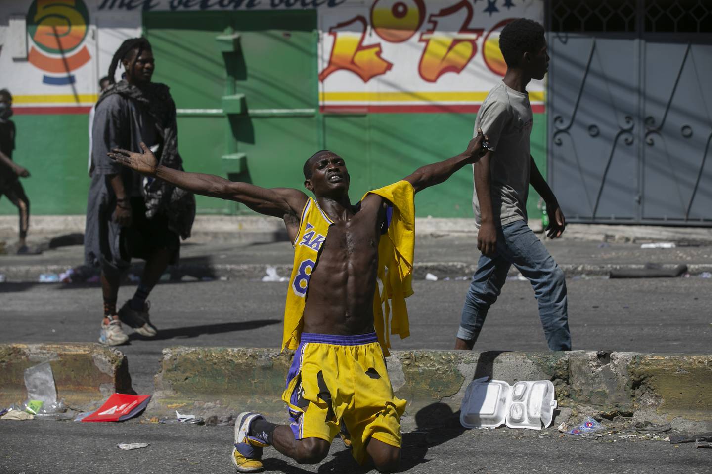 En demonstrant kneler og roper «rettferdighet for folket» under en demonstrasjon i Port-au-Prince torsdag. Foto: Odelyn Joseph / AP / NTB