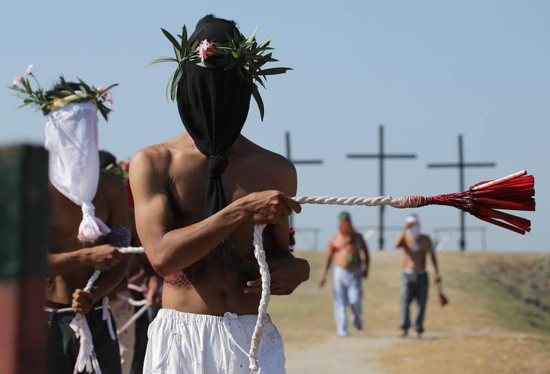 Hooded Filipino penitents flagellate during Good Friday rituals to atone for sins on Friday, April 3, 2015 in Pampanga province, northern Philippines. The ritual is frowned upon by church leaders in this predominantly Roman Catholic country. (AP Photo/Aaron Favila)