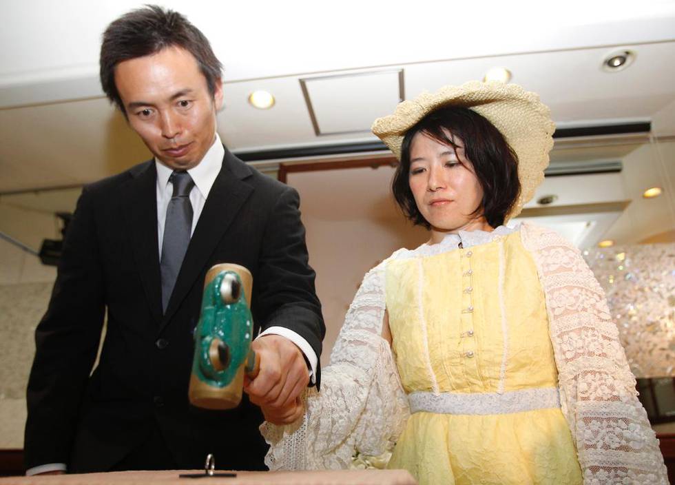 ENDELIG PUNKTUM: Tomoharu og Miki Saito tar sammen grep om hammeren for å banke bryllupsringene flate. Skilsmisseseremonien deres i Tokyo fant sted 3. juli 2011, dagen før de søkte om skilsmisse.