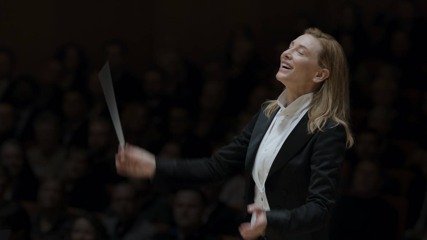 Orkesterdirigent Lydia Tár (Cate Blanchett) elsker å svinge taktstokken i hvit skjorte og svart jakke. (Foto: Focus Features)