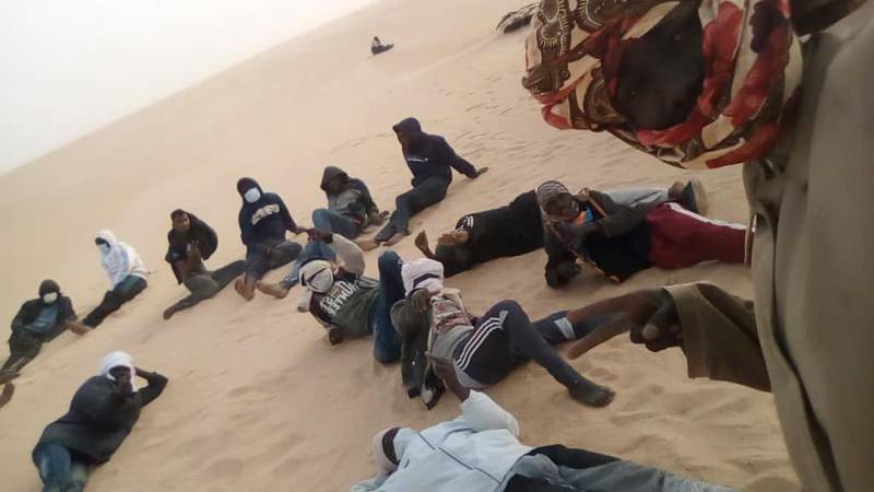 This March 22, 2020 provided by migrant Tayeb Saleh shows fellow migrants resting in the sand while they await help getting out in the Libyan Sahara near the border with Sudan. The Kufra detention center in southern Libya has accelerated expulsions of migrants during the coronavirus pandemic to Sudan and Chad. The drive under the harsh Sahara sun takes three to four days in open-air trucks, which often break down in the soft sand. (Tayeb Saleh via AP)