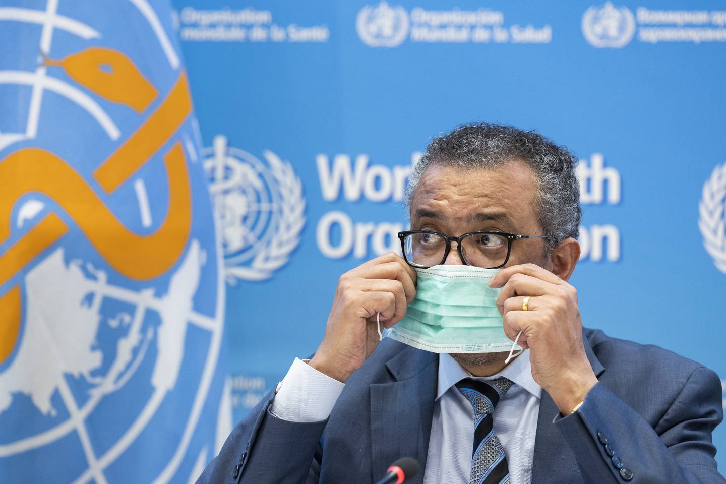 Tedros Adhanom Ghebreyesus, Director General of the World Health Organization (WHO), removes his protective face mask prior to speaking to the media regarding the coronavirus COVID-19 and WHO's global health priorities in 2022, during a new press conference, at the World Health Organization (WHO) headquarters in Geneva, Switzerland, Monday, Dec.  20, 2021. (Salvatore Di Nolfi/Keystone via AP)