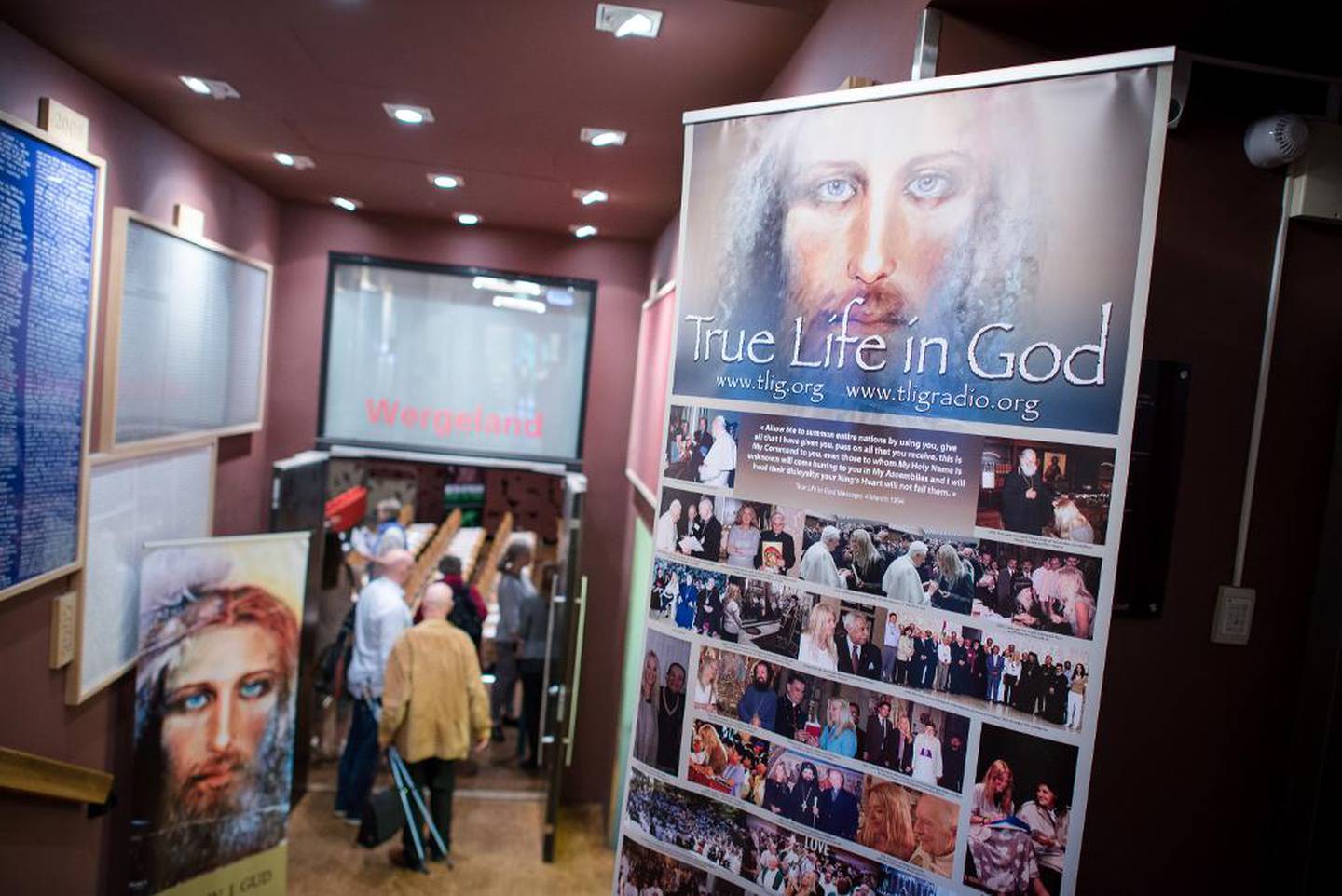 En plakat ved inngangen til møtet viser bilder av Vassula Rydén som møter folkemasser og kirkelige ledere over hele verden.