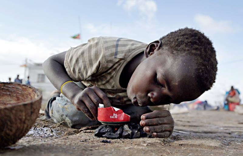 A young boy makes fire as he plays in Buzi district, 200 kilometers (120 miles) outside Beira, Mozambique, on Saturday, March 23, 2019.  A second week has begun of efforts to find and help tens of thousands of people after Cyclone Idai devastated a large swath of Mozambique. (AP Photo/Themba Hadebe)