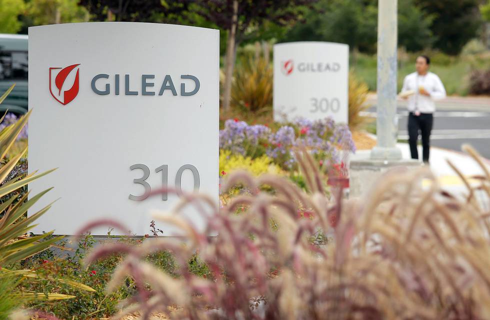 FILE - In this July 9, 2015, file photo, a man walks outside the headquarters of Gilead Sciences in Foster City, Calif. Gilead, the pharmaceutical giant that makes remdesivir, a promising coronavirus drug, has registered it as a rare disease treatment with U.S. regulators on Monday, March 23, 2020, a status that can potentially be worth millions in tax breaks and competition-free sales. (AP Photo/Eric Risberg, File)