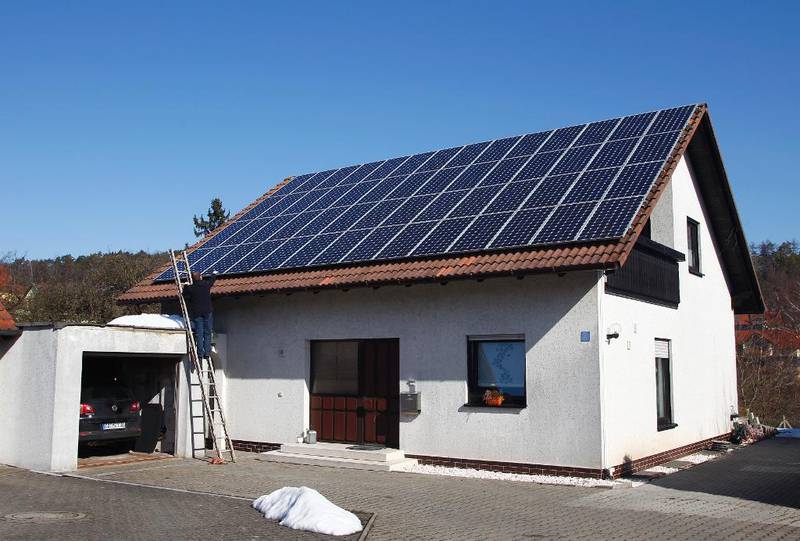 Denne huseieren setter opp 56 solcellepaneler på taket av boligen sin i Coburg i ­Tyskland. Halvparten av solenergien i Tyskland kommer fra solcelle­paneler som privat­personer ­eller bønder har installert.