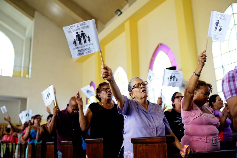 Worshippers wave paper flags that read in Spanish "I am in favour of the original design. The family as God created it. Wedding between man and woman", during a service at a Methodist Church in Havana, Cuba, October 4, 2018. Picture taken on October 4, 2018. REUTERS/Alexandre Meneghini