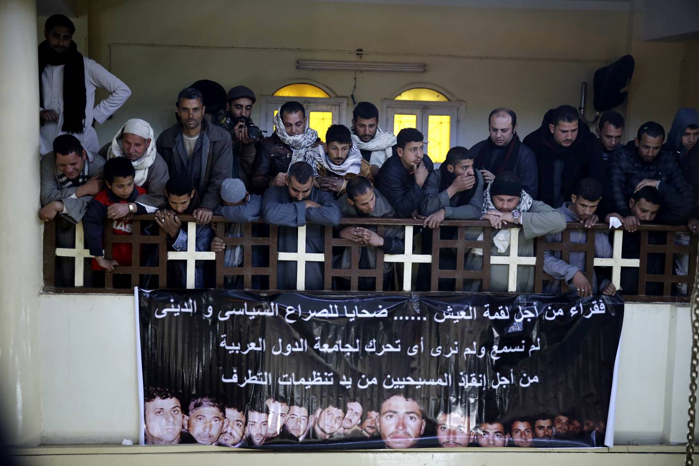 SØRGENDE: Dagen etter at IS-videoen kom ut, hang menigheten i Jomfru Maria-kirken i El Or opp et banner med ansiktene deres.