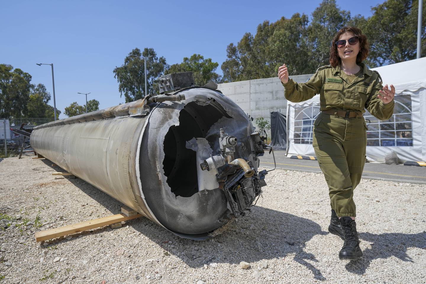 Israeli military deputy head of the IDF International press department, first lieutenant Masha Michelson, display to the media one of the Iranian ballistic missiles Israel intercepted over the weekend, in Julis army base, southern Israel, Tuesday, April 16, 2024. Israel says that Iran launched over 300 missiles and attack drones in the weekend attack. It says most of the incoming fire was intercepted, but a handful of missiles landed in Israel, causing minor damage and wounding a young girl. (AP Photo/Tsafrir Abayov)