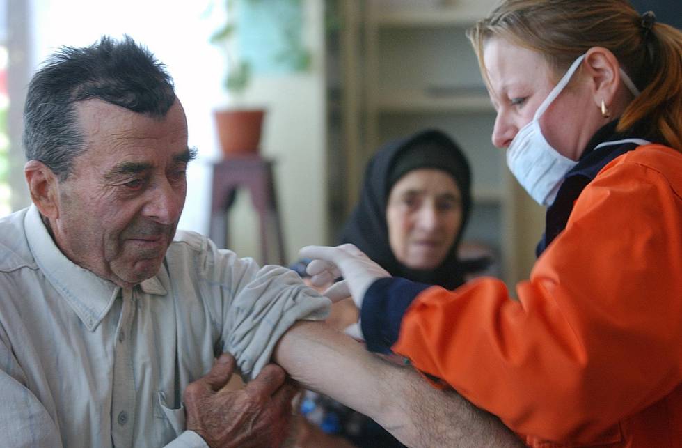 An elderly Romanian gets a flu vaccine in Scarlatesti, Romania, 200 kilometers north east of Bucharest, Sunday Nov. 27 2005. Authorities began culling thousands of domestic birds in this eastern Romanian village where a turkey has tested positive for the H5 subtype of bird flu.(AP Photo/Vadim Ghirda)