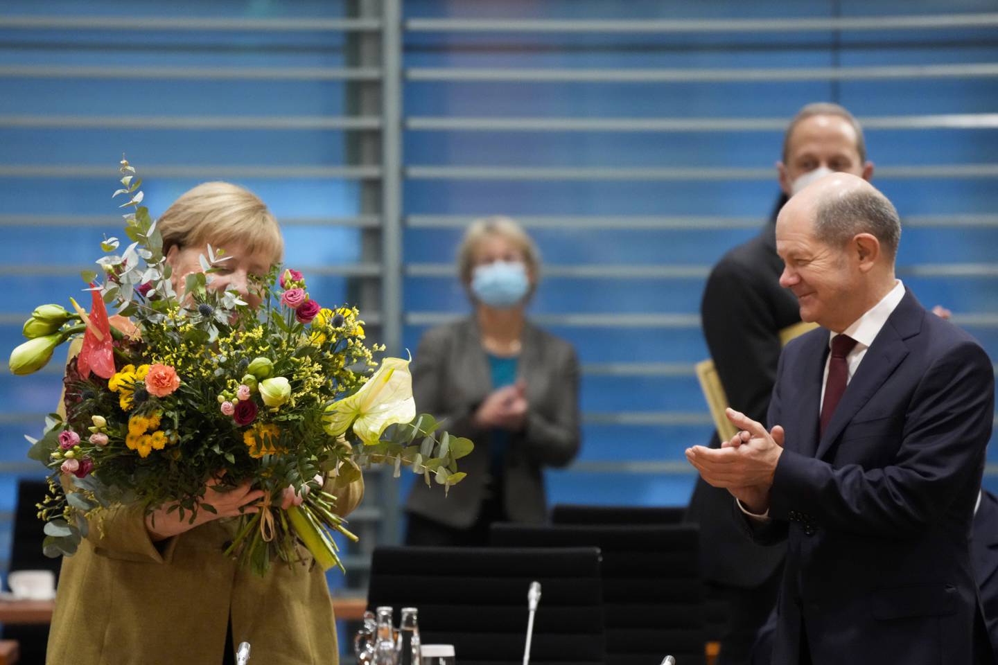 Scholz gir blomster til sin forgjenger Angela Merkel på hennes siste regjeringsmøte onsdag. Foto: Markus Schreiber / AP / NTB
