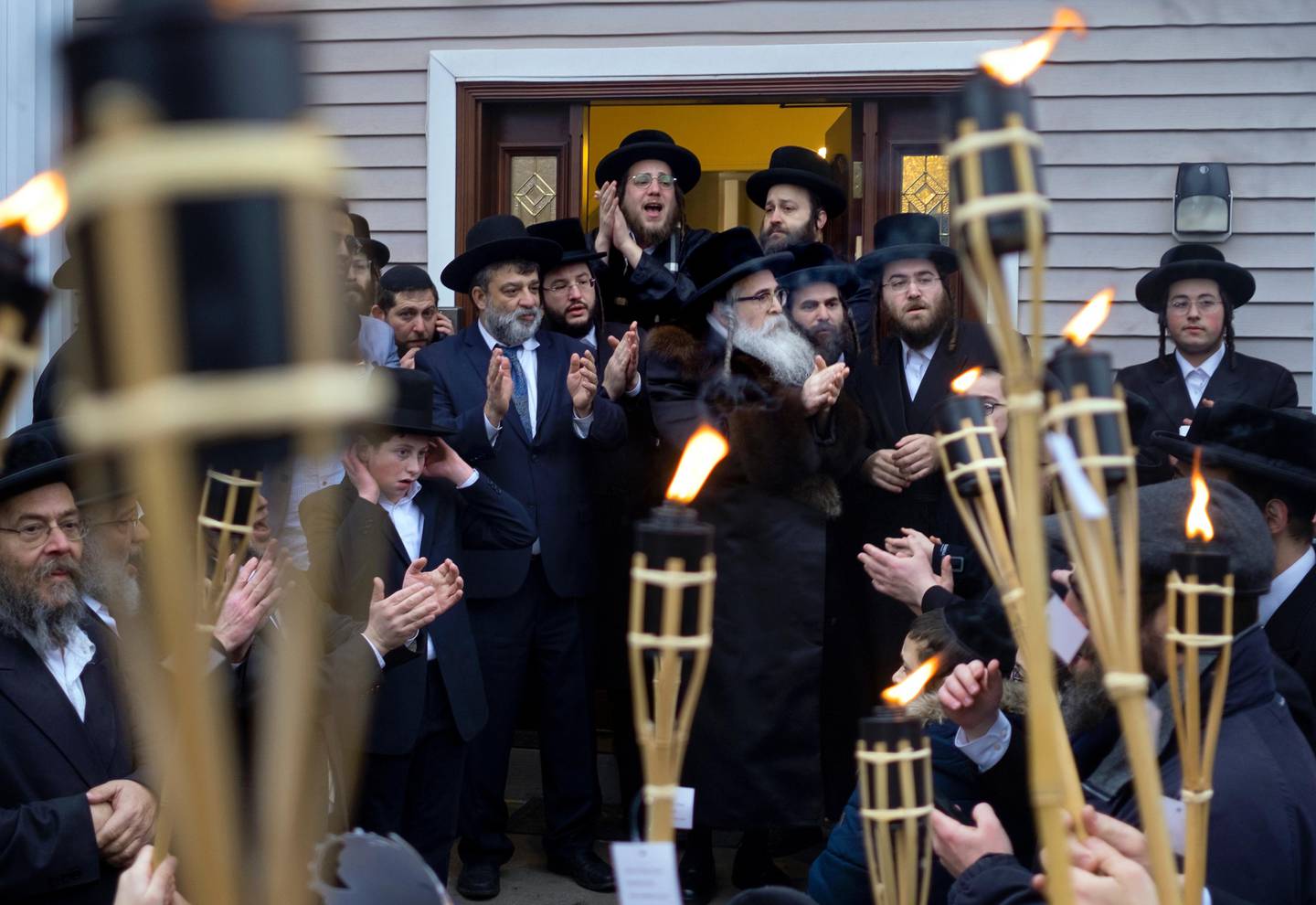Community members celebrate the arrival of a new Torah at Chaim Rottenberg residence, Sunday, Dec. 29, 2019, in Monsey, N.Y. A day earlier, a knife-wielding man stormed into the home and stabbed multiple people as they celebrated Hanukkah in the Orthodox Jewish community. (AP Photo/Craig Ruttle)