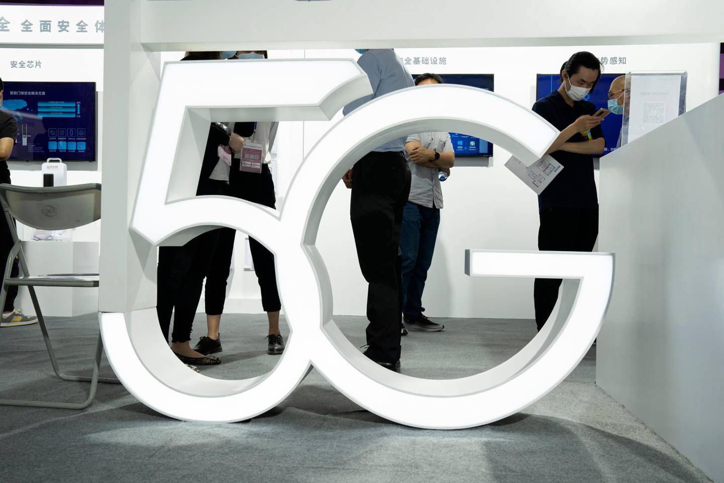 Visitors wearing mask to protect from the coronavirus walk past a 5G sign at the China Beijing International High Tech Expo in Beijing, China on Thursday, Sept. 17, 2020. (AP Photo/Ng Han Guan)