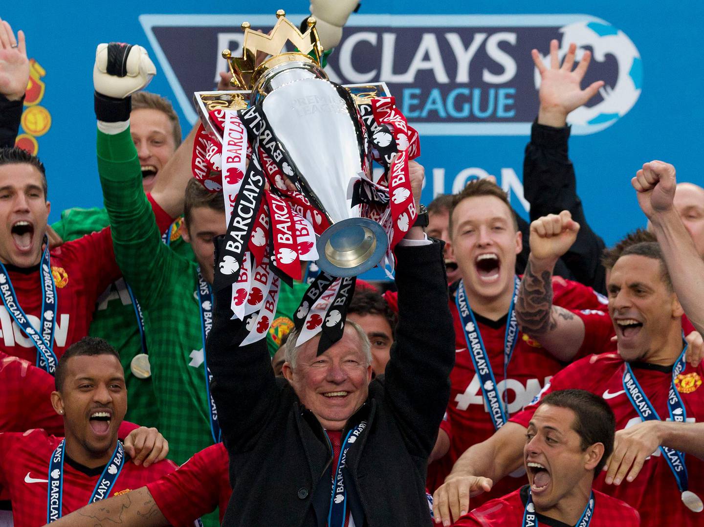 Manchester United's manager Sir Alex Ferguson, center, lifts the premier league trophy after his last home game in charge of the club, their English Premier League soccer match against Swansea City, at Old Trafford Stadium, Manchester, England, Sunday May 12, 2013. (AP Photo/Jon Super)