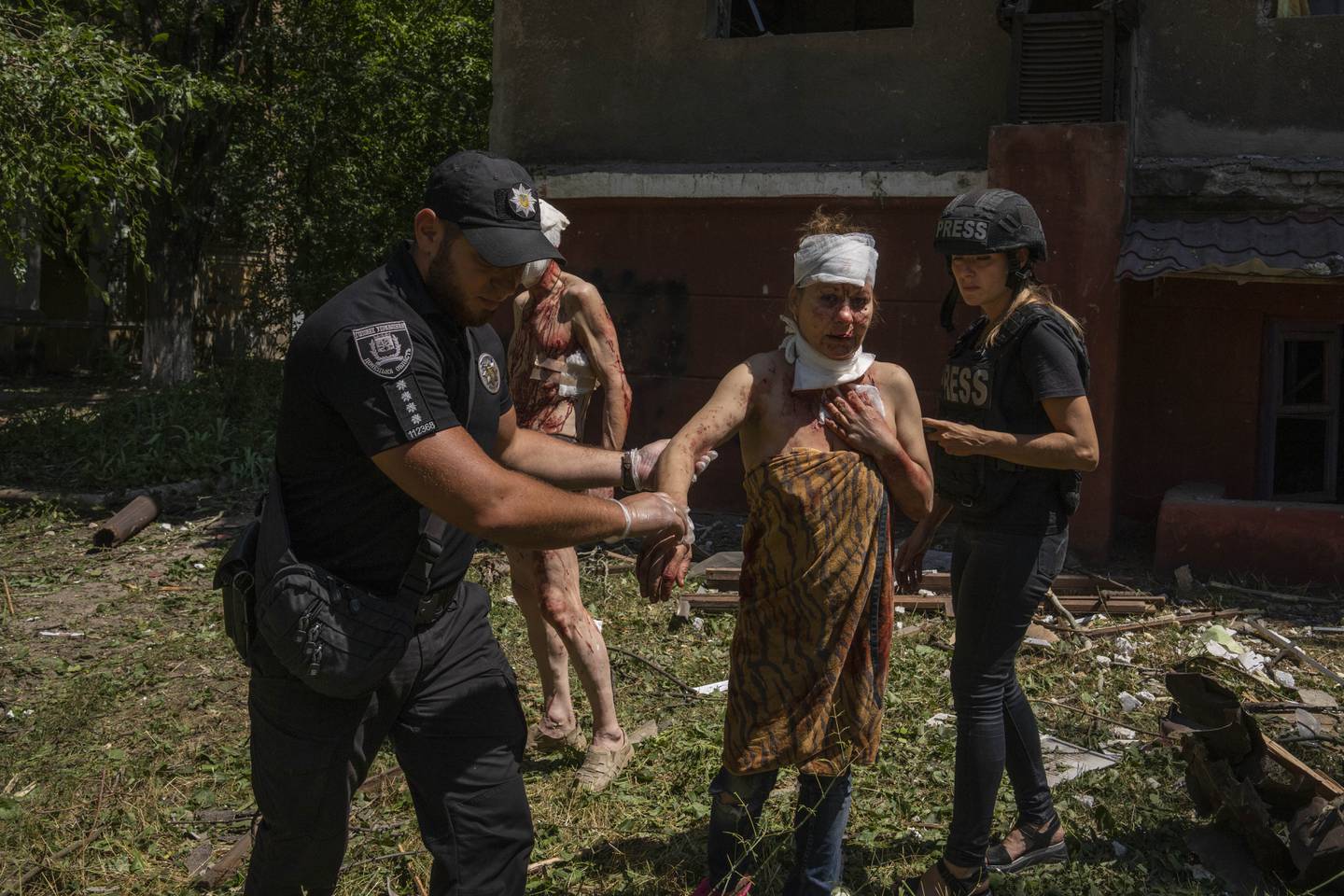 En politibetjent hjelper en kvinne som er såret i et russisk angrep mot et boligområde i Kramatorsk. Foto: Nariman El-Mofty / AP / NTB