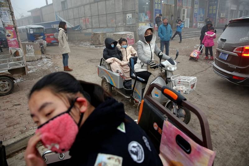 Kineserne sliter med giftig smog – «wu mai». Her prøver trafikantene i Shenfang i Hebei-provinsen å skjerme seg for den helsefarlige luften, som nådde alarmerende nivåer i desember og på nyåret.