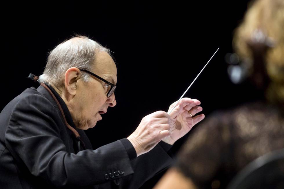 Italian composer Ennio Morricone conducts the Czech National Symphony Orchestra during his "60 Years of Music World Tour" in the Papp Laszlo Sports Arena in Budapest, Hungary, Sunday, Jan. 17, 2016. (Balazs Mohai/MTI via AP)