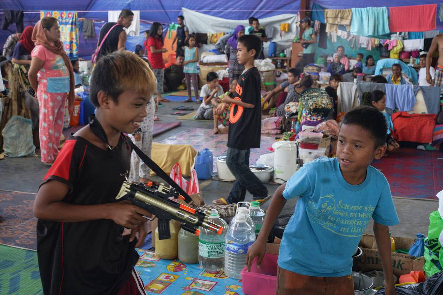Flere hundre drept og rundt 250.000 internt fordrevet fra flere områder på Mindanao siden opprøret startet 23. mai. Disse guttene morer seg med lekevåpen på et evakueringssenter i Saguiaran. 