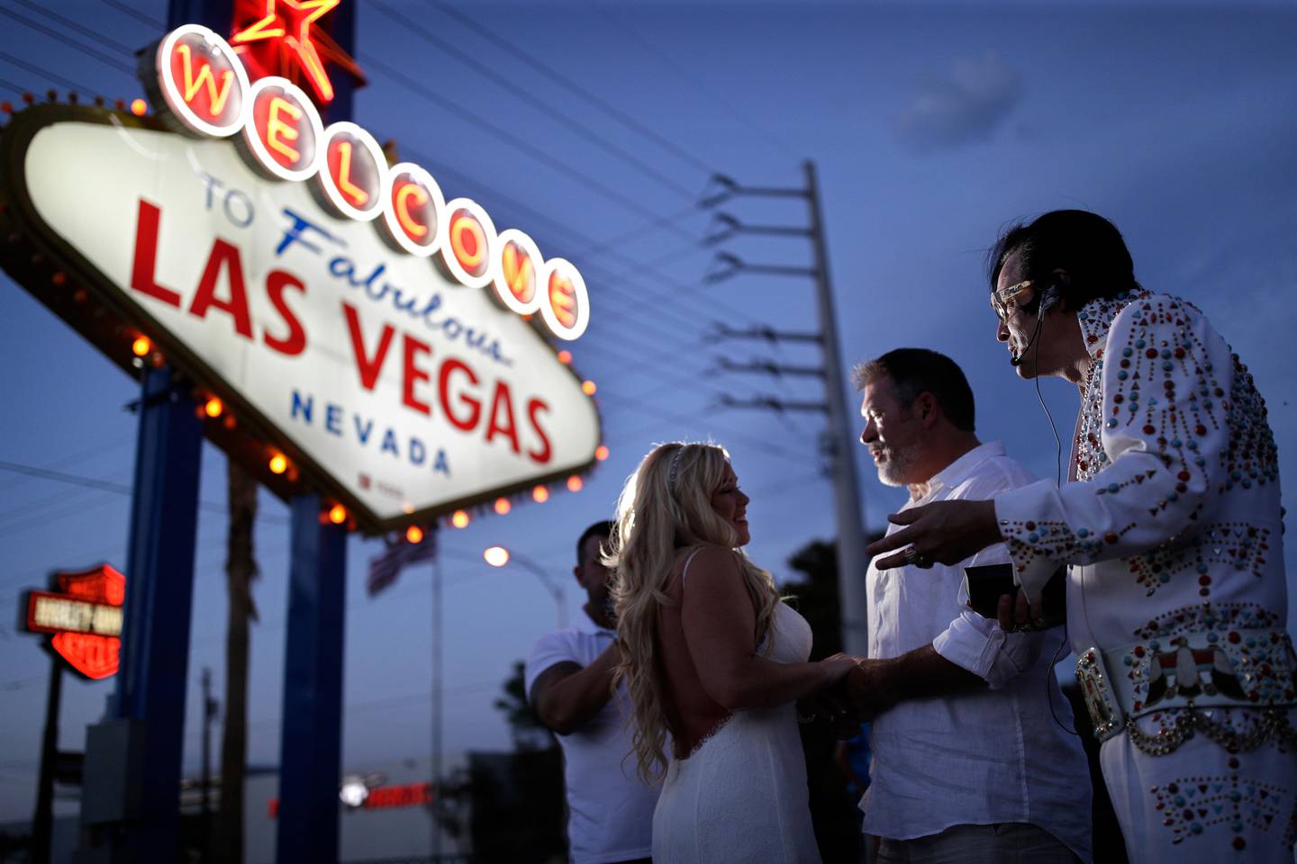 In this Aug. 1, 2017, photo, Eddie Powers, right, performs as Elvis during a wedding for Wil and Sarah Wilson in Las Vegas. Powers works full-time as an Elvis tribute artist performing at weddings and leading Elvis themed tours around Las Vegas. (AP Photo/John Locher)