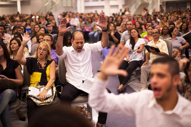 In this Sept. 25, 2014 photo, faithful raise their hands in prayer as they listen to Pentecostal pastor Silas Malafaia's preaching during a service at the Assemblies of God church in Rio de Janeiro, Brazil, Thursday, Sept. 25, 2014. The swelling ranks of Brazils socially conservative Pentecostal population now represent over one-fifth of the electorate just three decades after barely registering any presence at all. (AP Photo/Leo Correa) / TT / kod 436