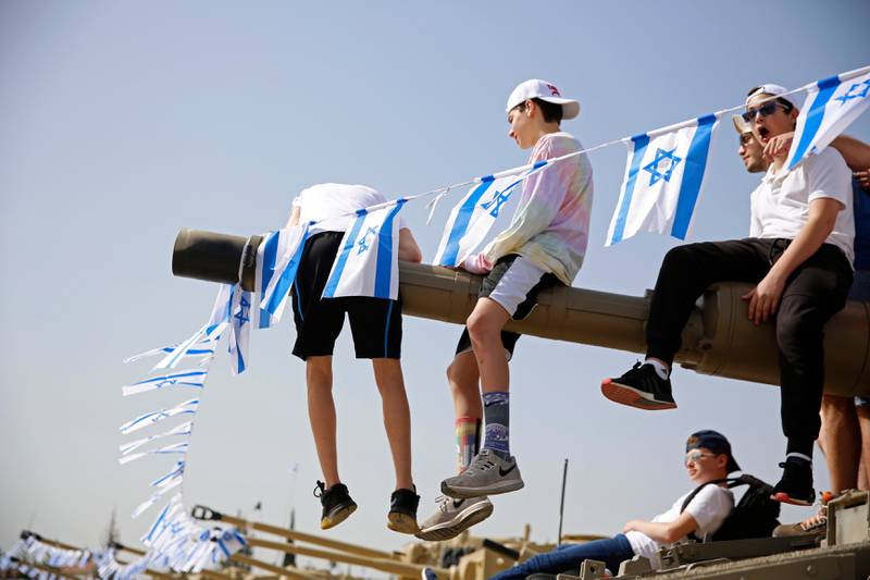 Barn bruker en tanks som klatrestativ under onsdagens minnedag for falne israelske soldater, som i år ble en del av landets 70-årsfeiring.