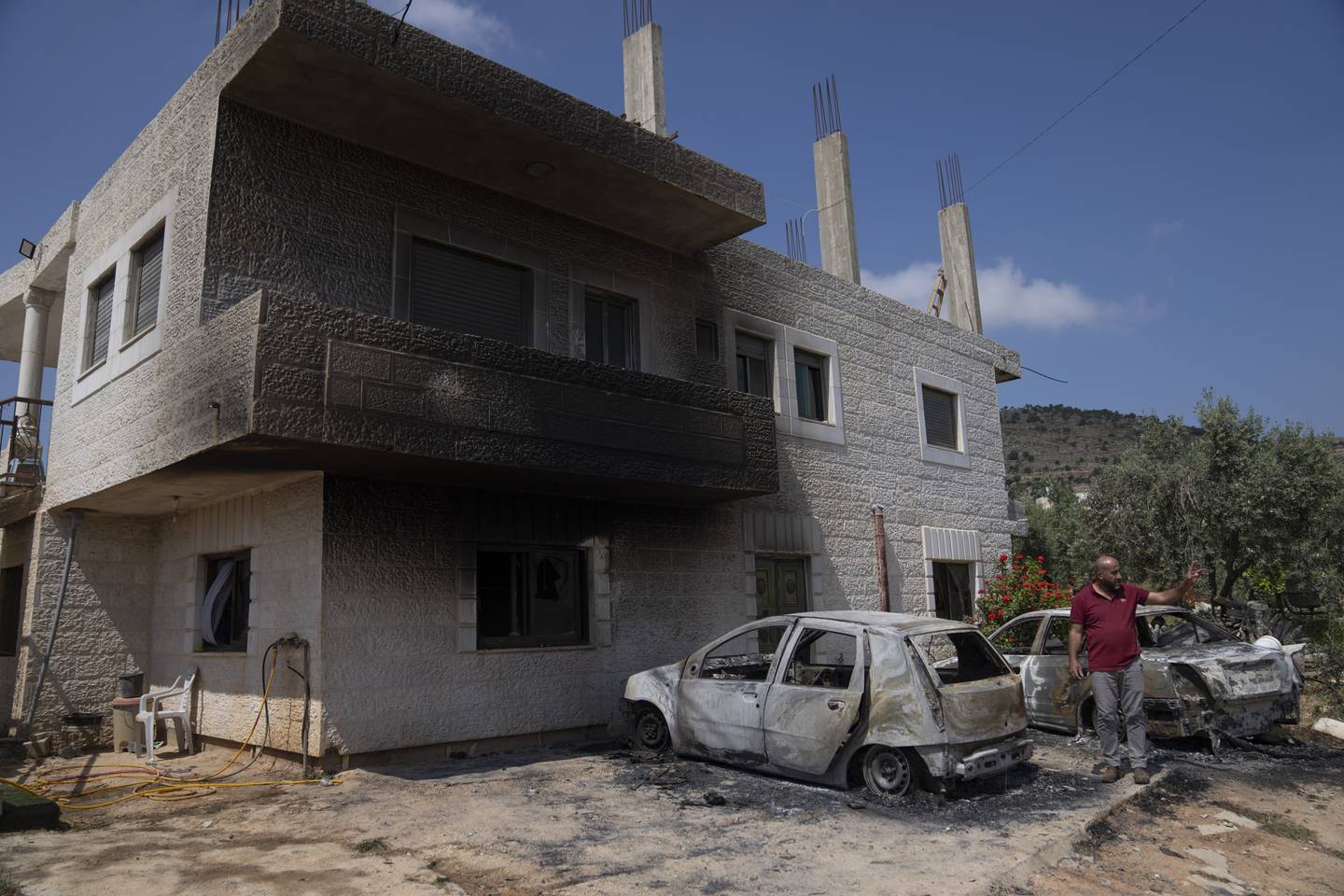 Akef Abu Alia inspiserer skadene på huset sitt og bilene sine etter at bosettere som lette etter en savnet tenåring, angrep landsbyen hans. Foto: Nasser Nasser / AP / NTB