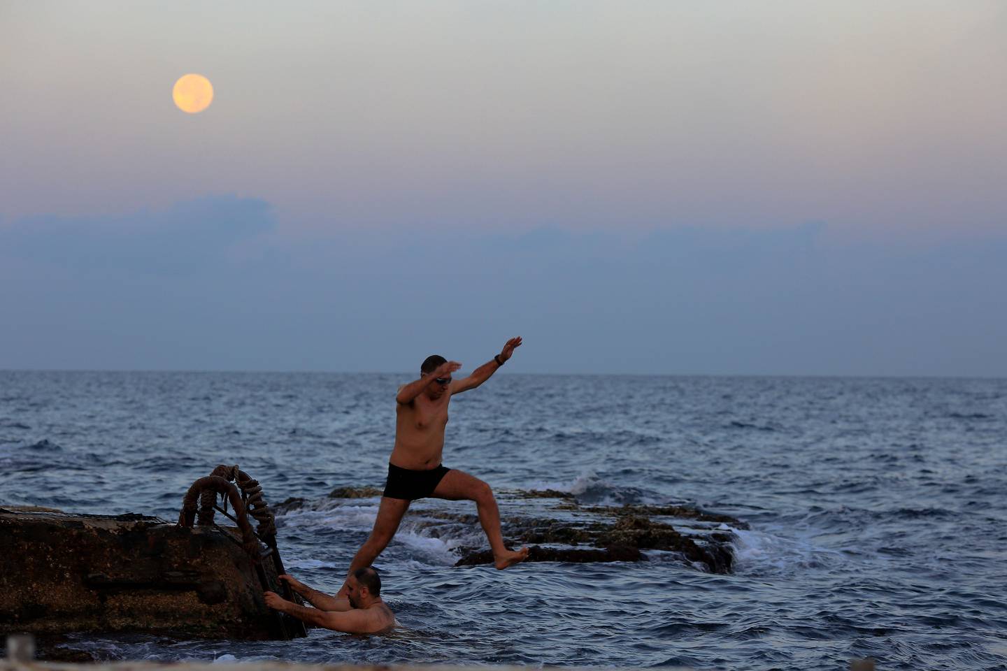 A Lebanese man jumps in the water as the moon rises over the Mediterranean Sea on the seafront promenade in Beirut, Lebanon, Tuesday, Nov. 15, 2016. The brightest moon in almost 69 years lit up the sky, during its closest approach to earth as the "Supermoon" reached its most luminescent phase. The moon won't be this close again until Nov. 25, 2035. (AP Photo/Hassan Ammar)