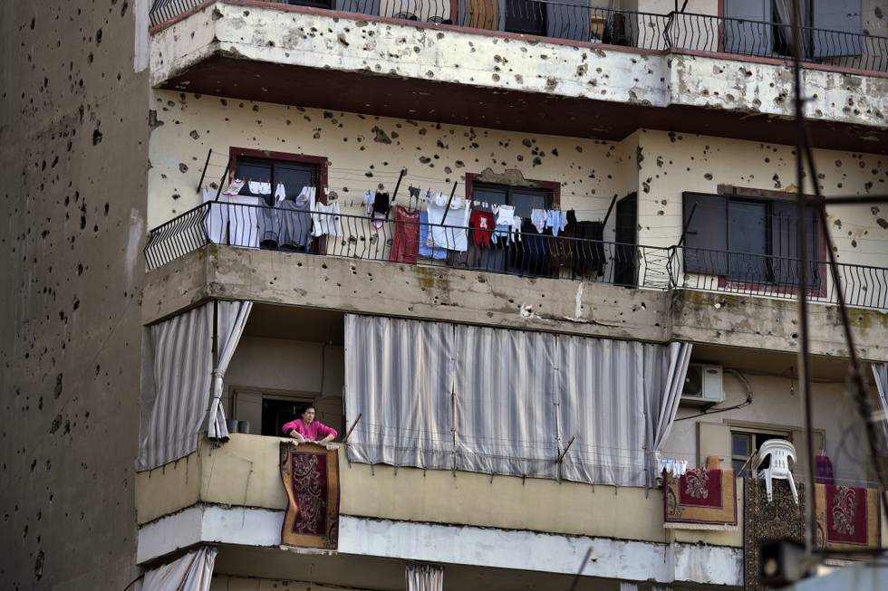 En kvinne rister et teppe fra balkongen i den libanesiske byen Tripoli. Arkivfoto: Bilal Hussein / AP / NTB