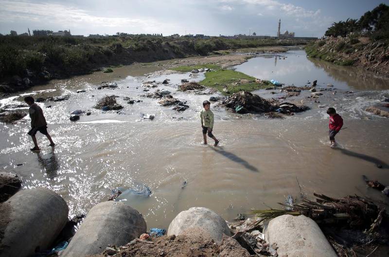 Kloakk: Barn vasser gjennom kloakkinfisert vann ved Gaza by. Daglig renner millionvis av liter med urenset kloakk­ ut i Middelhavet fra den tett befolkede Gazastripen.