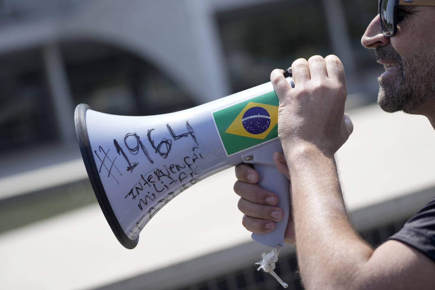 TILHENGER: Dom Verneck som er tilhenger av Brasils president Jair Bolsonaro og leder av intervensjonistbevegelsen, bruker en megafon merket på portugisisk; "#1964 militær intervensjon», med henvisning til militærkuppet i 1964. Bolsonaro er kritisert for å hylle tiden under diktaturet i landet.