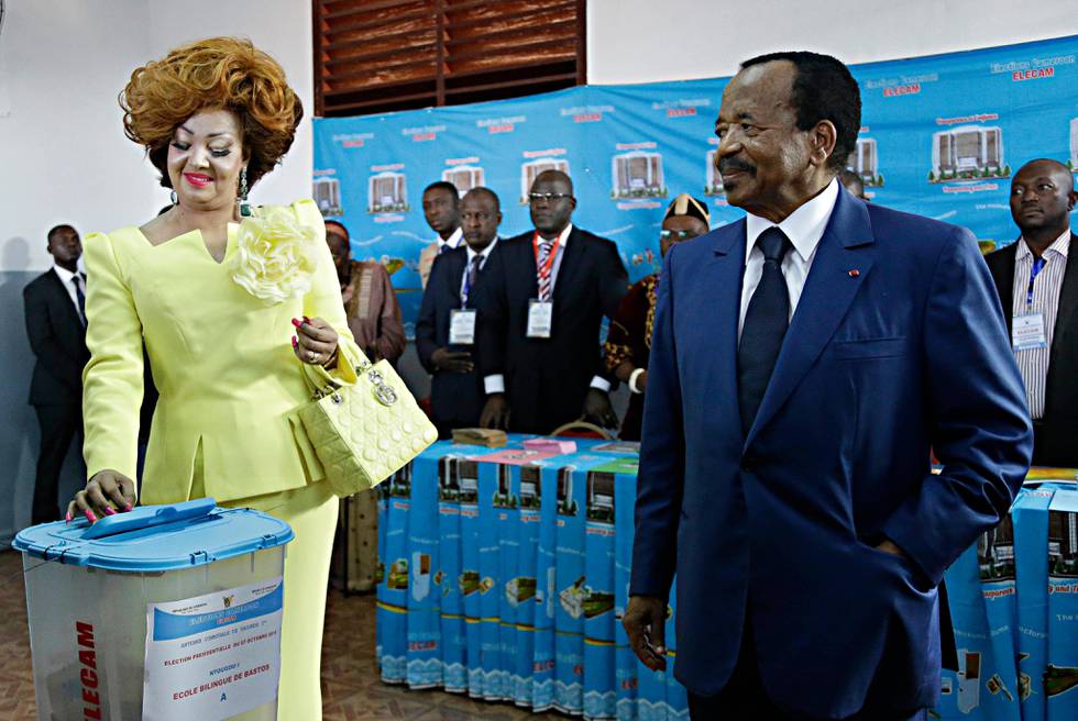 Cameroon's Incumbent President Paul Biya, right, looks on as his wife Chantal Biya, left, casts her vote during the Presidential elections in Yaounde, Cameroon, Sunday Oct. 7, 2018. Polls opened Sunday in Cameroon as Africa's oldest leader is widely expected to win another term, while separatists threaten to disrupt the election and many people who have fled the unrest are unable to vote. (AP Photo/Sunday Alamba)