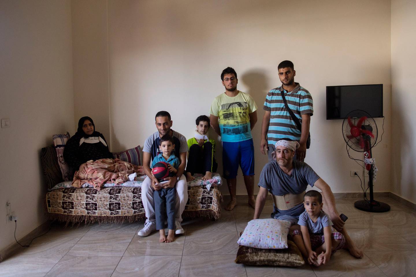 The family of Ali Kinno pose for a photograph from left to right, Fatmeh Kinno, 45, Mahmoud, 25, Hoda 11, Qoteiba 17, Mustafa, 28, Ali, 45, Ahmad, 6 during an interview at a temporary apartment in the coastal town of Jiyeh, south of Beirut, Lebanon, Tuesday, Sept. 15, 2020. The Kinno family from Syria's Aleppo region was devastated in the wake of the Aug. 4 explosion at the Beirut port, their tragic story reflects the particular pain of Syrian refugee families in Lebanon, which is now home to about a million Syrians.  (AP Photo/Hassan Ammar)