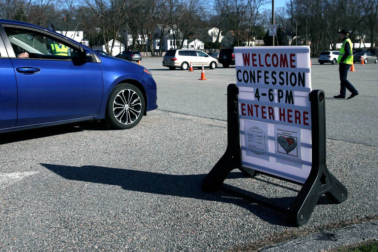 In this Monday, April 6, 2020 photo, cars line up for confession, held in the parking lot due to the virus outbreak, at St. John the Evangelist Catholic Church in Chelmsford, Mass. After Massachusetts Gov. Charlie Baker issued an emergency order prohibiting most gatherings of over 10 people due to the coronavirus, the parish moved their confessional outdoors with drive-up service. (AP Photo/Charles Krupa)