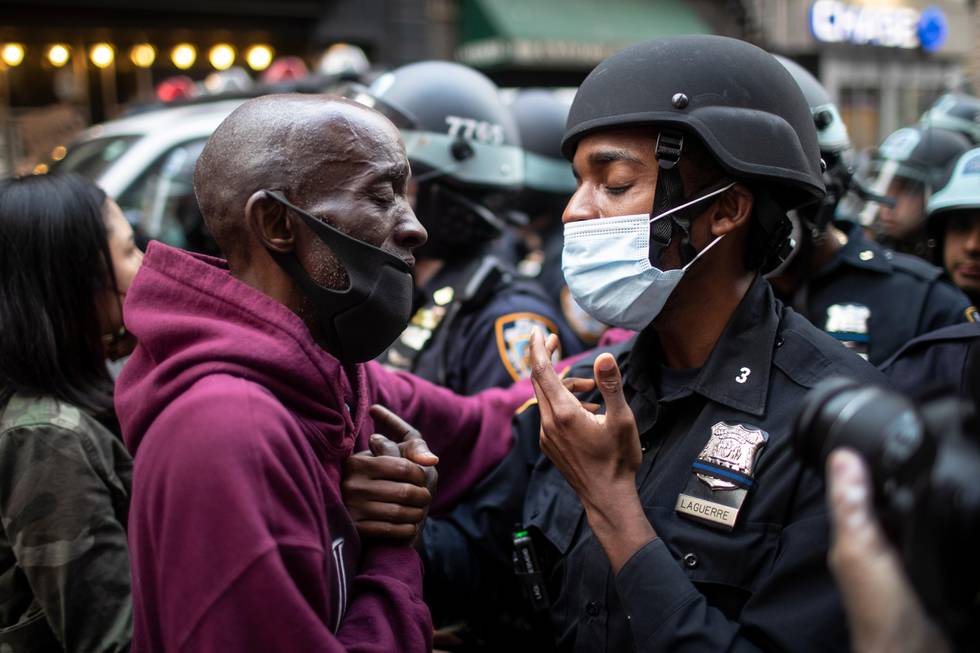 A protester and a police officer shake hands in the middle of a standoff during a solidarity rally calling for justice over the death of George Floyd Tuesday, June 2, 2020, in New York. Floyd died after being restrained by Minneapolis police officers on May 25. (AP Photo/Wong Maye-E)