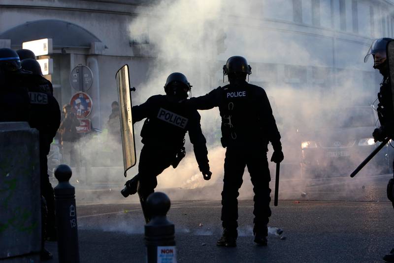 Riot police offiers kick back a tear gas grenade during a protest Saturday, Jan. 19, 2019 in Marseille, southern France. Thousands of yellow vest protesters rallied Saturday in several French cities for a 10th consecutive weekend, despite a national debate launched this week by President Emmanuel Macron aimed at assuaging their anger. (AP Photo/Claude Paris)