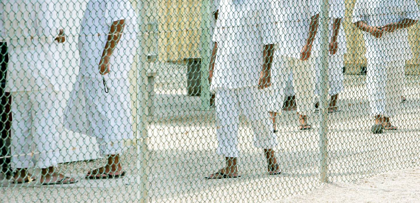 ** EDS: PHOTO HAS BEEN REVIEWED BY US MILITARY OFFICIALS ** Detainee's walk in the court yard at Camp 4 inside of the maximum security prison Camp Delta at Guantanamo Bay Naval Base, Thursday,  Aug.  26, 2004, in Guantanamo Bay, Cuba. This week the U.S. Military held preliminary hearings for four detainee's charged with conspiricy to commit war crimes. (AP Photo/Mark Wilson, Pool)