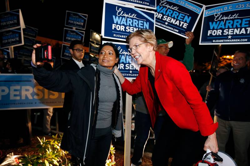Sen. Elizabeth Warren poses for a selfie while greeting supporters before a debate with her Republican opponent Geoff Diehl in Boston, Friday, Oct. 19, 2018. (AP Photo/Michael Dwyer)