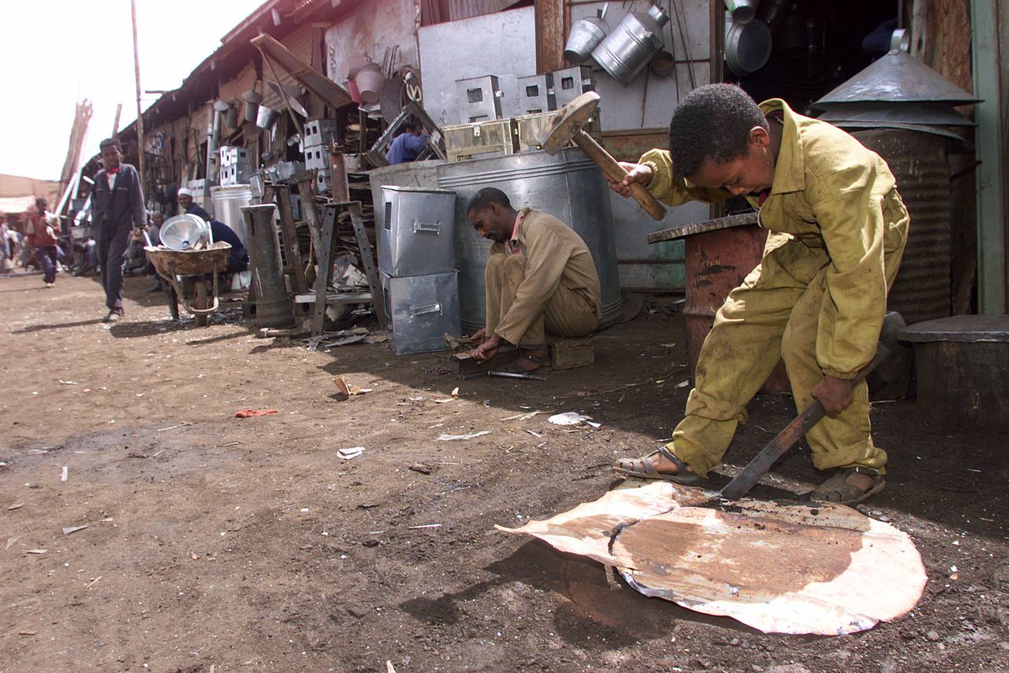 A child works at cutting a piece of metal at a metal recycling shop in Asmara, Eritrea Saturday, June 3, 2000. Workers in Asmara recycle virtually everything, but the two-year war with Ethiopia is threatening to erode Eritrea's fabled self reliance. (AP Photo/Jean-Marc Bouju)