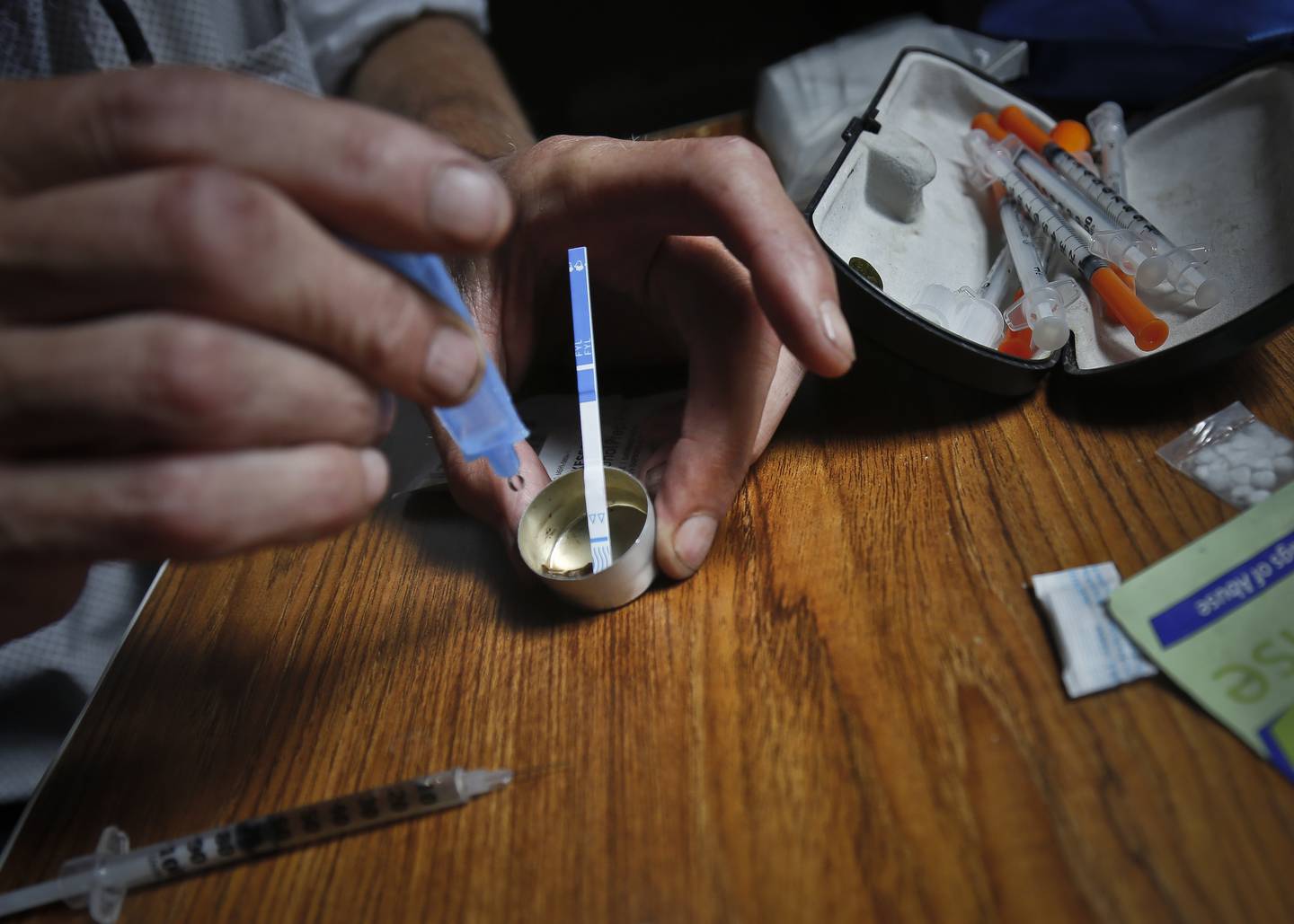 I USA er det syntetiske stoffet fentanyl vanlegaste grunnen til overdoser. På dette bildet testar ein heroinavhengig i New York stoffet han har kjøpt for fentanyl ved hjelp av ein teststrimle, for å unngå overdose.