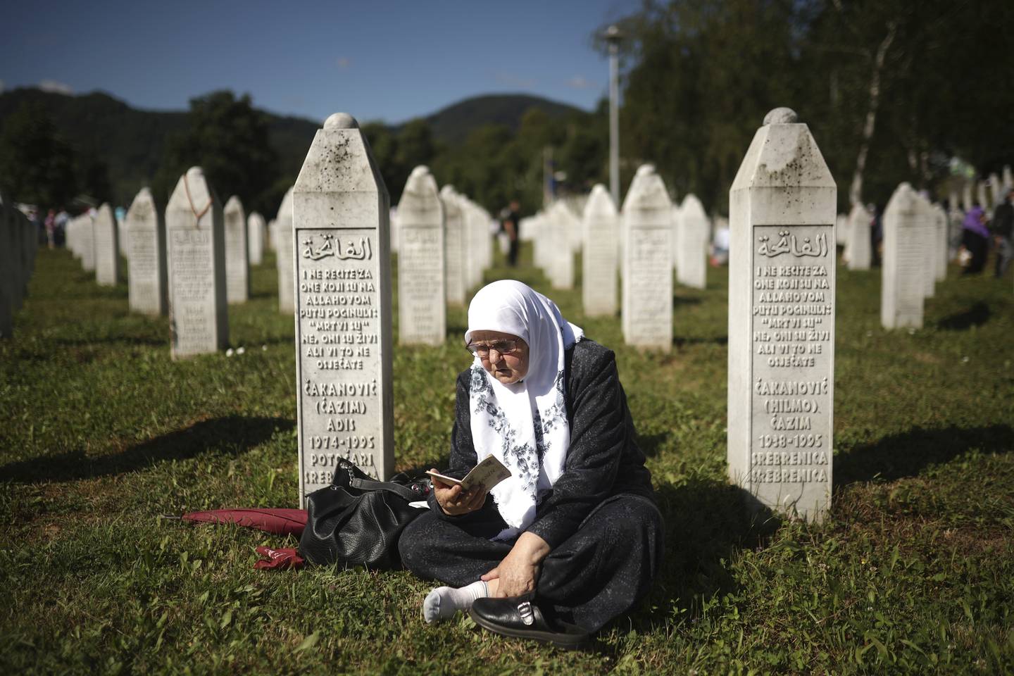 En kvinne ber ved gravsteinene ved minnestedet for Srebrenica-massakren mandag.. Foto: Armin Durgut / AP / NTB