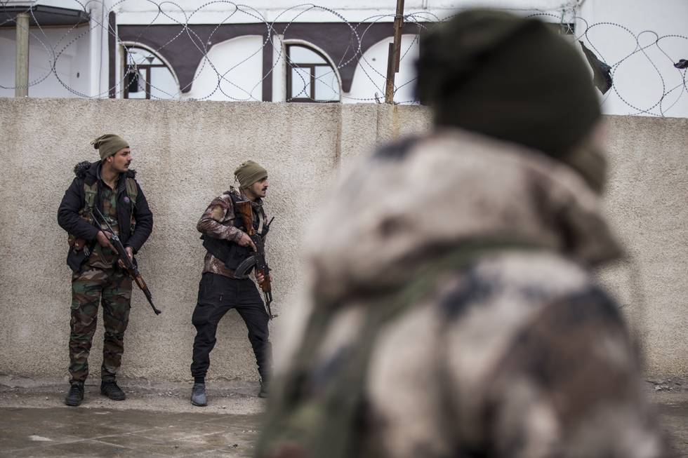 Soldater fra den kurdiske SDF-styrken holder vakt ved fengselet i Hasakeh som ble stormet av jihadister forrige uke. SDF sier de har tatt tilbake kontrollen over fengselet, men lørdag brøt det ut nye kamper. Foto: Baderkhan Ahmad / AP / NTB