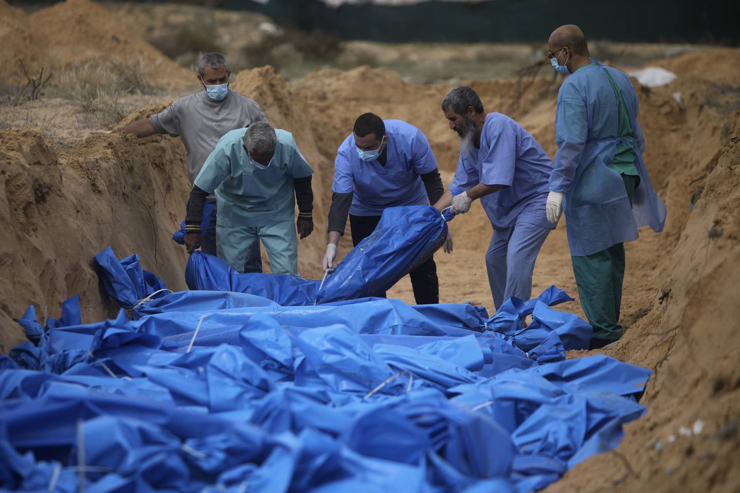Over 70 prosent av de over 18.000 som er drept på Gazastripen de siste to månedene, var ifølge helsemyndighetene barn og kvinner. Her legges ofre i en massegrav i Khan Younis. Foto: AP / NTB 