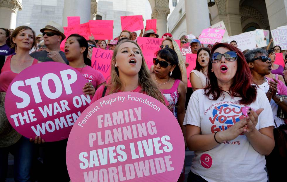 FILE - In this Sept. 9, 2015, file photo, Planned Parenthood supporters rally for women's access to reproductive health care on "National Pink Out Day'' at Los Angeles City Hall. One of President-elect Donald Trump?Äôs first, and defining, acts next year could come on Republican legislation to cut off taxpayer money from Planned Parenthood. Trump sent mixed signals during the campaign about the 100-year-old organization which provides birth control, abortions and various women's health services. He said "millions of women are helped by Planned Parenthood," but also endorsed efforts to defund it. (AP Photo/Nick Ut, File)